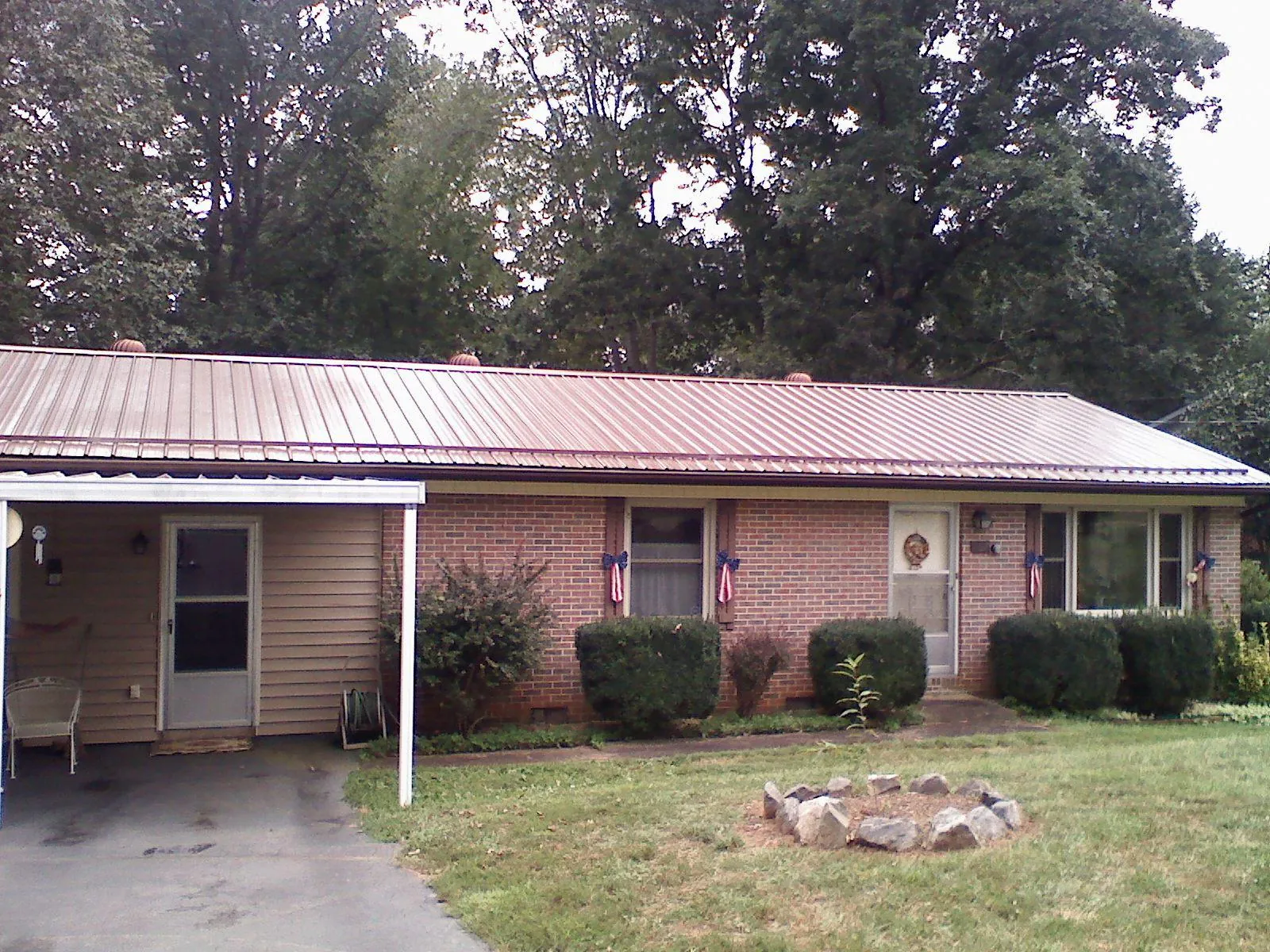 Bronze metal roof and carport on a brick ranch home — Roof Repair work by our crew in Lewisburg